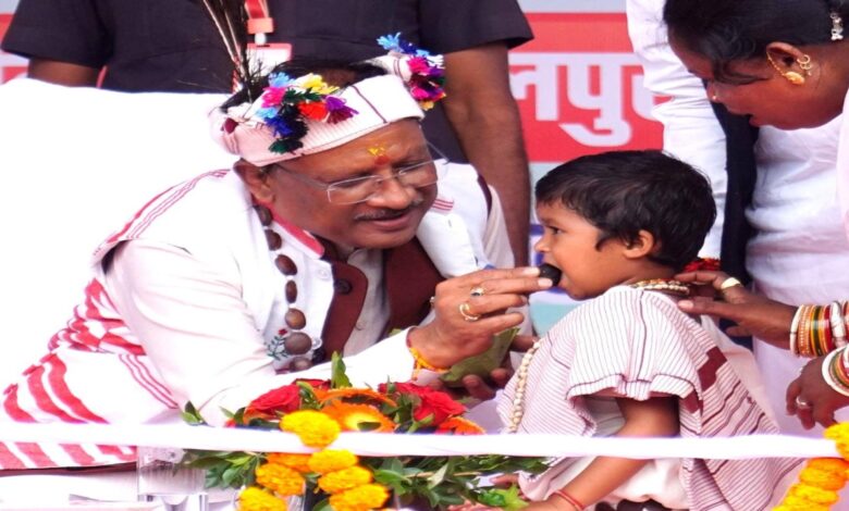 The Chief Minister sat the little girl on his lap and fed her laddus.